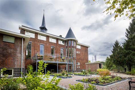 Zijaanzicht van het klooster met torentjes en nieuwe aanbouw
